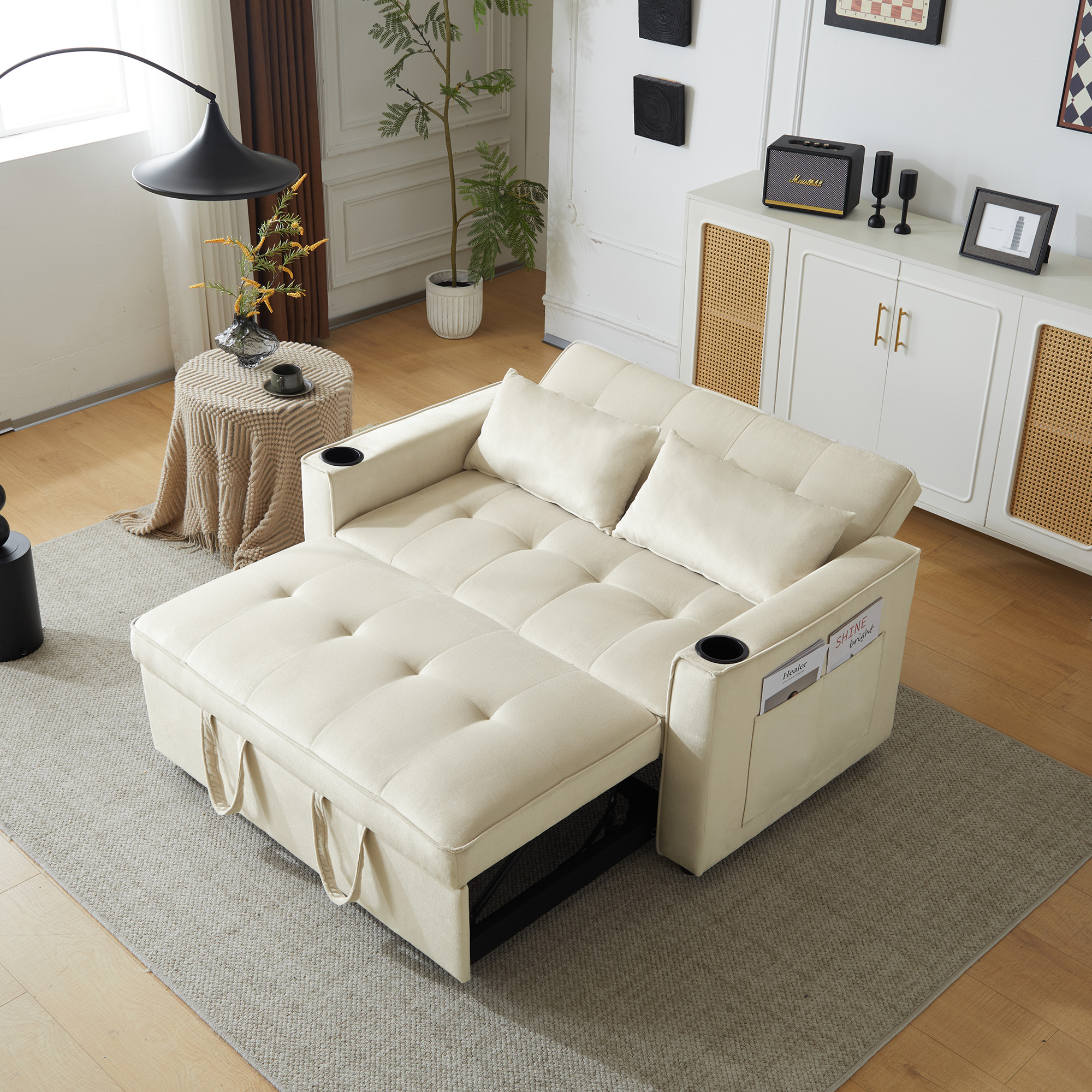 Canapé convertible 2 places beige en velours avec porte-gobelets, poches latérales et coussins