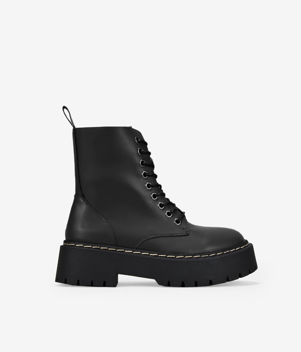Bosanova Botas militares estilo punk confeccionadas en piel vegana con plataforma dentada y cordones hasta la parte superior. Cierre con cremallera.